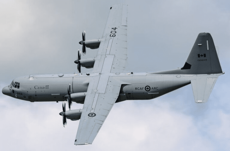 Royal Canadian Air Force plane mid-flight against a cloudy sky.