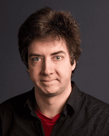 Homme aux cheveux noirs portant une chemise noire et un col rouge.