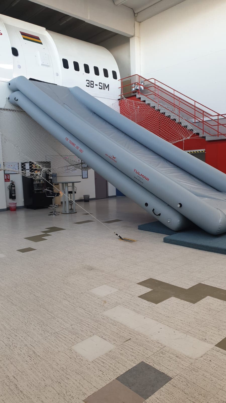 Un toboggan d'urgence pour avion est déployé à l'intérieur d'un centre de formation.